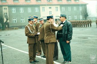 Fot. 53c. Dowódca 13 Pułku Zmechanizowanego wręcza odznaki pułkowe.